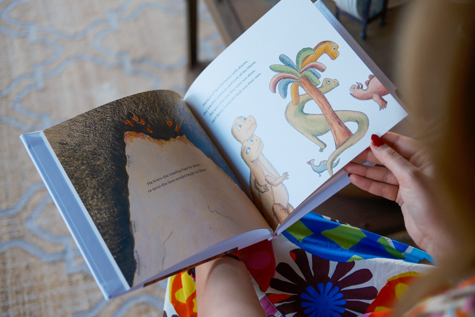 A child reading an illustrated dinosaur spread from Spike's Big Roar
